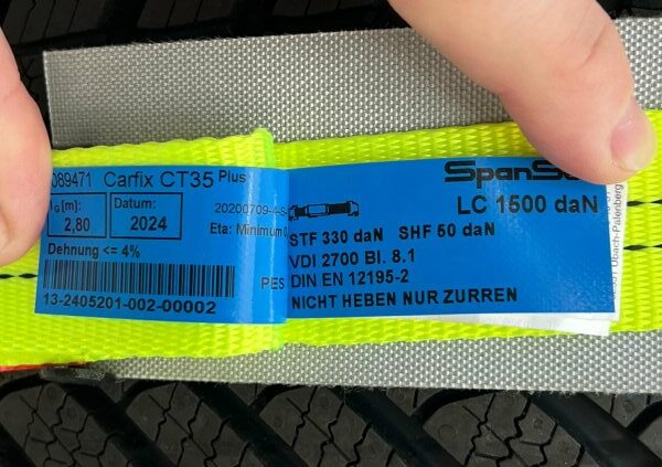 Label eines Zurrgurtes für den Fahrzeugtransport